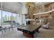 Elegant lounge with a pool table, stone fireplace, high ceilings, and large windows overlooking city views at 860 Peachtree Ne St # 1417, Atlanta, GA 30308