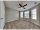 Bedroom with plush carpeting, fan, three windows, and neutral paint at 1550 Royale Castle Dr, Lawrenceville, GA 30043