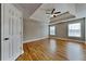 Spacious bedroom featuring hardwood floors, tray ceiling with fan, and natural light at 1550 Royale Castle Dr, Lawrenceville, GA 30043