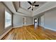 Large bedroom featuring hardwood floors, tray ceilings with a fan and plenty of natural light at 1550 Royale Castle Dr, Lawrenceville, GA 30043