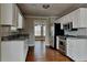 Modern kitchen featuring granite countertops, stainless steel appliances, and white cabinetry at 1550 Royale Castle Dr, Lawrenceville, GA 30043