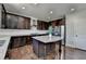 Stylish kitchen equipped with stainless steel appliances and a center island with dark brown cabinets at 2705 Fox Hunt Way, Cumming, GA 30041