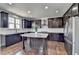 Gourmet kitchen with stainless steel appliances, a granite island, and dark brown cabinetry at 2705 Fox Hunt Way, Cumming, GA 30041