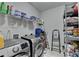 Functional laundry room with front load washer/dryer, storage shelves and tiled floor at 2705 Fox Hunt Way, Cumming, GA 30041
