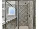 Modern tiled shower with glass door and built-in shelving, offering a spa-like experience at 2705 Fox Hunt Way, Cumming, GA 30041