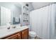 Bathroom with a white shower curtain, cabinets, sink, and shelves, offering a functional and stylish space at 2984 Gayle Manor Ln, Snellville, GA 30078