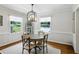 A formal dining room features hardwood floors, white walls, large windows, and a decorative chandelier at 389 Valley Brook Ne Dr, Atlanta, GA 30342