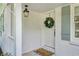 Charming, covered front porch of a white brick home featuring stylish light fixture and front door at 389 Valley Brook Ne Dr, Atlanta, GA 30342