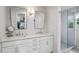 A bright main bathroom features a double sink vanity, marble countertops, and a glass door shower at 389 Valley Brook Ne Dr, Atlanta, GA 30342