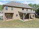 Spacious backyard with a covered patio, lush green grass, and a two-story home at 4735 Belcrest Way, Cumming, GA 30040