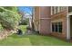 Brick home with an outdoor patio, lush grass, and mature landscaping at 2016 Westbourne Way, Johns Creek, GA 30022