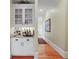 Wet bar area features white cabinets, a granite countertop, and hardwood floors at 2016 Westbourne Way, Johns Creek, GA 30022