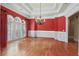 Elegant dining room with red walls, hardwood floors, and bright, shuttered windows at 2016 Westbourne Way, Johns Creek, GA 30022