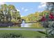 Scenic pond with a central fountain, framed by lush greenery and vibrant red flowers, offering a tranquil view at 2016 Westbourne Way, Johns Creek, GA 30022