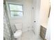 This bathroom has a white toilet, window, modern vanity, and a shower with patterned shower curtain at 2638 Cleburne Pkwy, Powder Springs, GA 30127