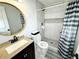 Stylish bathroom featuring a shower, a modern vanity with granite counters, and a circular mirror at 2638 Cleburne Pkwy, Powder Springs, GA 30127