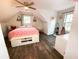 This cozy bedroom features a unique sloped ceiling, wood floors, a ceiling fan, and plenty of natural light at 2638 Cleburne Pkwy, Powder Springs, GA 30127