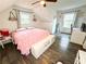 This cozy bedroom features a unique sloped ceiling, wood floors, a ceiling fan, and plenty of natural light at 2638 Cleburne Pkwy, Powder Springs, GA 30127