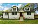 Charming two-story home featuring a light exterior, dormer windows, and a welcoming front porch at 2638 Cleburne Pkwy, Powder Springs, GA 30127