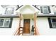 Welcoming front entryway with a solid wood door, decorative columns, and new porch and freshly painted exterior at 2638 Cleburne Pkwy, Powder Springs, GA 30127