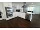 Bright kitchen boasts white cabinetry, stainless steel appliances, and hardwood floors, creating a modern and inviting space at 2638 Cleburne Pkwy, Powder Springs, GA 30127