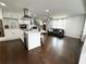 Open-concept kitchen features white cabinets, stainless steel appliances, and a center island, flowing into the living room at 2638 Cleburne Pkwy, Powder Springs, GA 30127