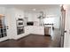 Updated kitchen with white cabinetry, stainless steel appliances, and dark hardwood floors, seamlessly blending into the living space at 2638 Cleburne Pkwy, Powder Springs, GA 30127