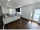 Bright living room featuring a large sectional couch, hardwood floors, and natural light at 2638 Cleburne Pkwy, Powder Springs, GA 30127