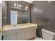 Small bathroom with wallpaper, big mirror, vanity, and commode at 3312 Northcrest Rd # C, Atlanta, GA 30340