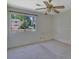 Bedroom with view of exterior landscape, ceiling fan, and tan carpet at 3312 Northcrest Rd # C, Atlanta, GA 30340