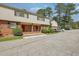 Brick and vinyl sided townhome with a red door and well manicured shrubs at 3312 Northcrest Rd # C, Atlanta, GA 30340