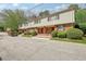 Brick and vinyl sided townhome with a red door and well manicured shrubs at 3312 Northcrest Rd # C, Atlanta, GA 30340