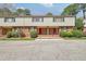 Brick and vinyl sided townhome with a red door and well manicured shrubs at 3312 Northcrest Rd # C, Atlanta, GA 30340
