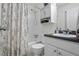 Clean bathroom with a shower-tub combination, storage cabinet, and dark granite countertop to compliment white cabinets at 3689 Essex Ave # 16, Atlanta, GA 30339