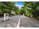 Community entrance with gate, well-manicured landscaping, and mature trees at 3689 Essex Ave # 16, Atlanta, GA 30339