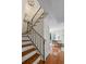 Stairway with wood treads and black metal railing leading into a comfortably furnished living space with natural light at 3689 Essex Ave # 16, Atlanta, GA 30339