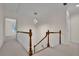 Hallway featuring wood railings, carpeted floors, and contemporary lighting at 4650 Riversound Dr, Snellville, GA 30039
