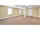 Spacious carpeted basement area with two windows and a support pillar at 503 Clearwater Dr, Mcdonough, GA 30252