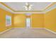 This bedroom has yellow walls, white trim, carpet flooring, and a ceiling fan at 503 Clearwater Dr, Mcdonough, GA 30252