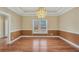 Dining area featuring hardwood floors, a tray ceiling, and stylish chandelier, perfect for entertaining at 503 Clearwater Dr, Mcdonough, GA 30252