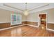 Open dining area with wood floors, modern lighting fixture, and an adjacent view into the kitchen at 503 Clearwater Dr, Mcdonough, GA 30252