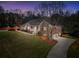 Attractive brick home with a covered porch, long driveway, and a well-kept lawn during twilight at 503 Clearwater Dr, Mcdonough, GA 30252