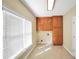 Laundry room featuring wooden cabinets, washer/dryer hookups, and natural light from a window at 503 Clearwater Dr, Mcdonough, GA 30252