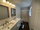 Bathroom featuring double sinks, updated fixtures, bright lighting, and a shower-tub combo at 2322 Rock Mill Ne Ln, Conyers, GA 30013