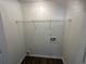 Laundry area featuring modern dark wood floors, white walls, and a wire rack at 2322 Rock Mill Ne Ln, Conyers, GA 30013