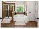 Luxurious bathroom features a separate shower, soaking tub, and a large window for natural light at 3070 Jardin Nw Ln, Kennesaw, GA 30152