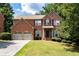Traditional two-story brick home with mature landscaping, two-car garage, and concrete driveway at 3070 Jardin Nw Ln, Kennesaw, GA 30152