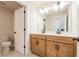 Well-lit bathroom featuring a double sink vanity with warm wood cabinets at 3962 Adler Cir, Buford, GA 30519