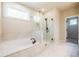 Bright bathroom features a soaking tub and glass enclosed shower with black hardware at 3962 Adler Cir, Buford, GA 30519
