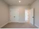 Bedroom with neutral carpet and walls, double door closet, and natural light at 3962 Adler Cir, Buford, GA 30519